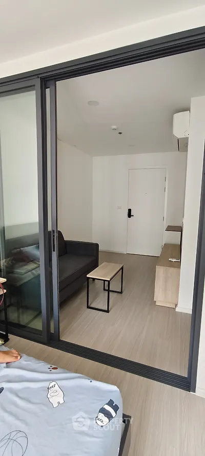 Modern living room with sliding glass doors and minimalist furniture in a stylish apartment.