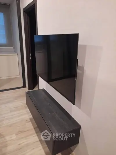 Modern living room with wall-mounted TV and sleek console unit.