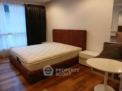 Spacious bedroom with elegant hardwood flooring and stylish bed frame, perfect for comfort and relaxation.