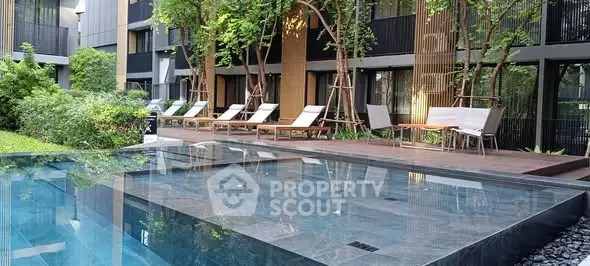 Luxurious modern apartment complex with serene pool and lush greenery