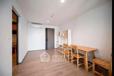 Spacious modern living room with sleek wooden flooring, minimalist furniture, and ample natural light, perfect for urban living.