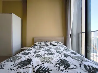 Cozy bedroom with modern decor and large window offering city views