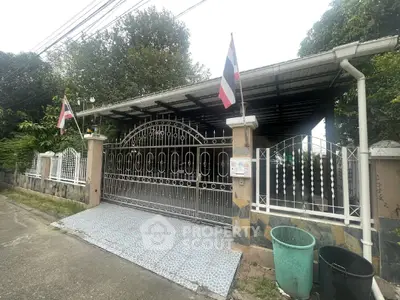Charming gated property with covered parking and lush greenery in a serene neighborhood.