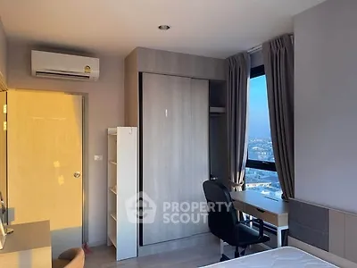 Modern bedroom with city view, featuring a workspace and air conditioning.