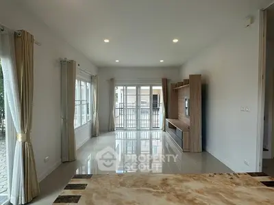 Spacious living room with large windows and modern entertainment unit