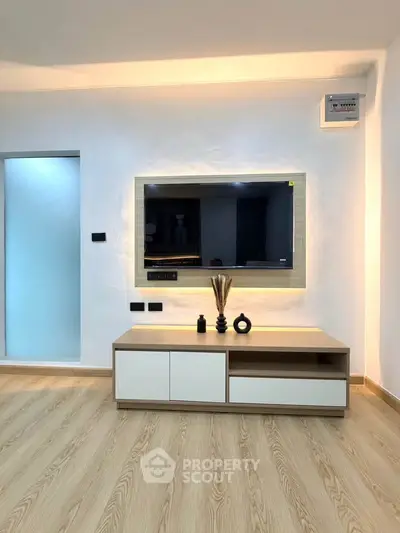 Modern living room with sleek TV unit and wooden flooring, perfect for contemporary homes.