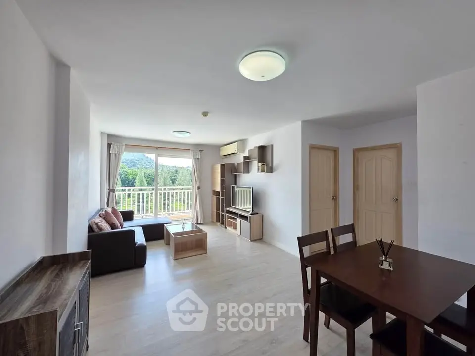 Spacious living room with modern furniture and balcony view