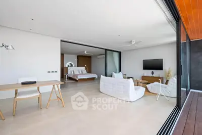 Spacious modern living room with open layout and elegant furnishings, featuring a seamless transition to a luxurious bedroom.