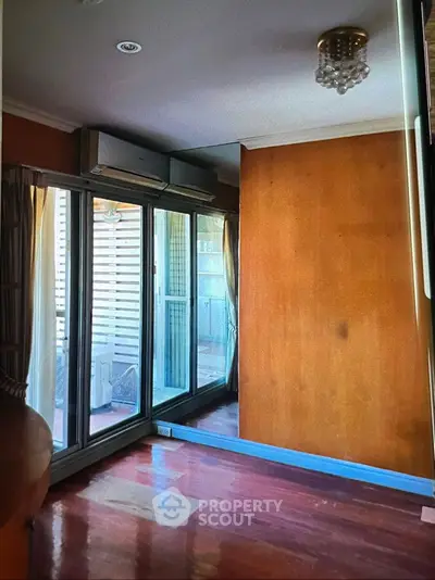 Cozy room with wooden flooring and large mirrored closet doors