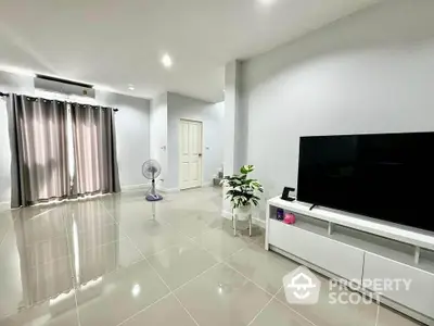 Spacious modern living room with sleek tile flooring and large TV unit