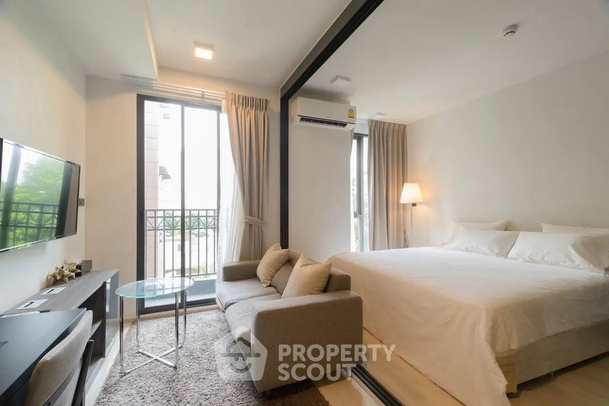 Modern studio apartment with cozy living area and balcony view