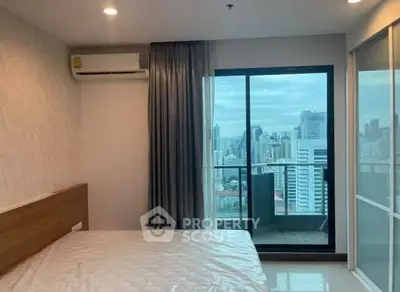 Modern bedroom with city view and balcony access in high-rise apartment
