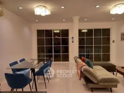 Elegant living room with modern furniture and stylish lighting, featuring a spacious layout and large windows.