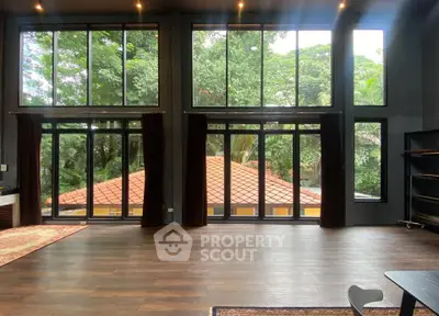 Spacious living room with large windows and lush garden view