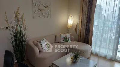 Chic living room with cozy sofa and city view balcony, perfect for relaxation.