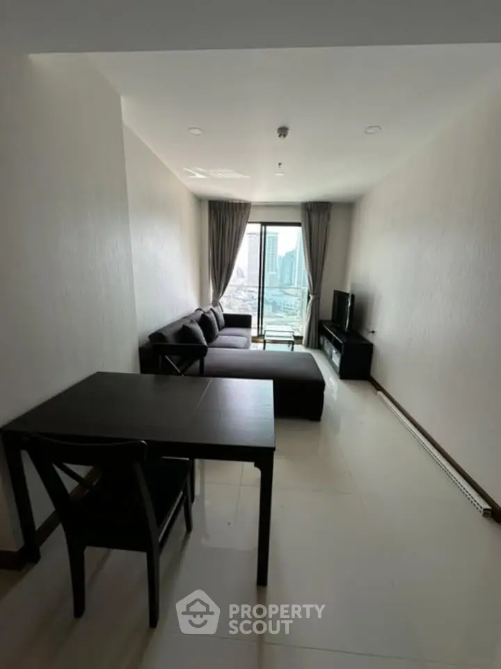 Modern living room with city view, featuring sleek furniture and large windows for natural light.