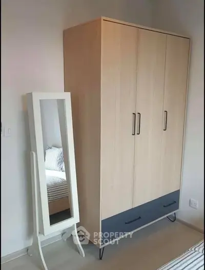 Modern bedroom with stylish wardrobe and full-length mirror