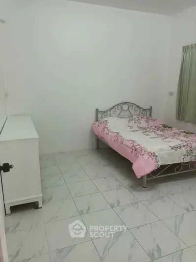 Cozy bedroom with floral bedding and minimalist decor, perfect for a peaceful retreat.