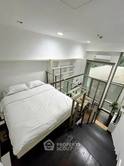 Modern loft bedroom with sleek design and large windows offering natural light