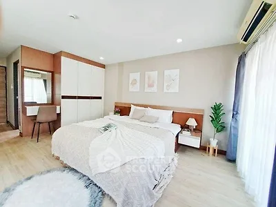 Spacious bedroom with modern decor and natural light