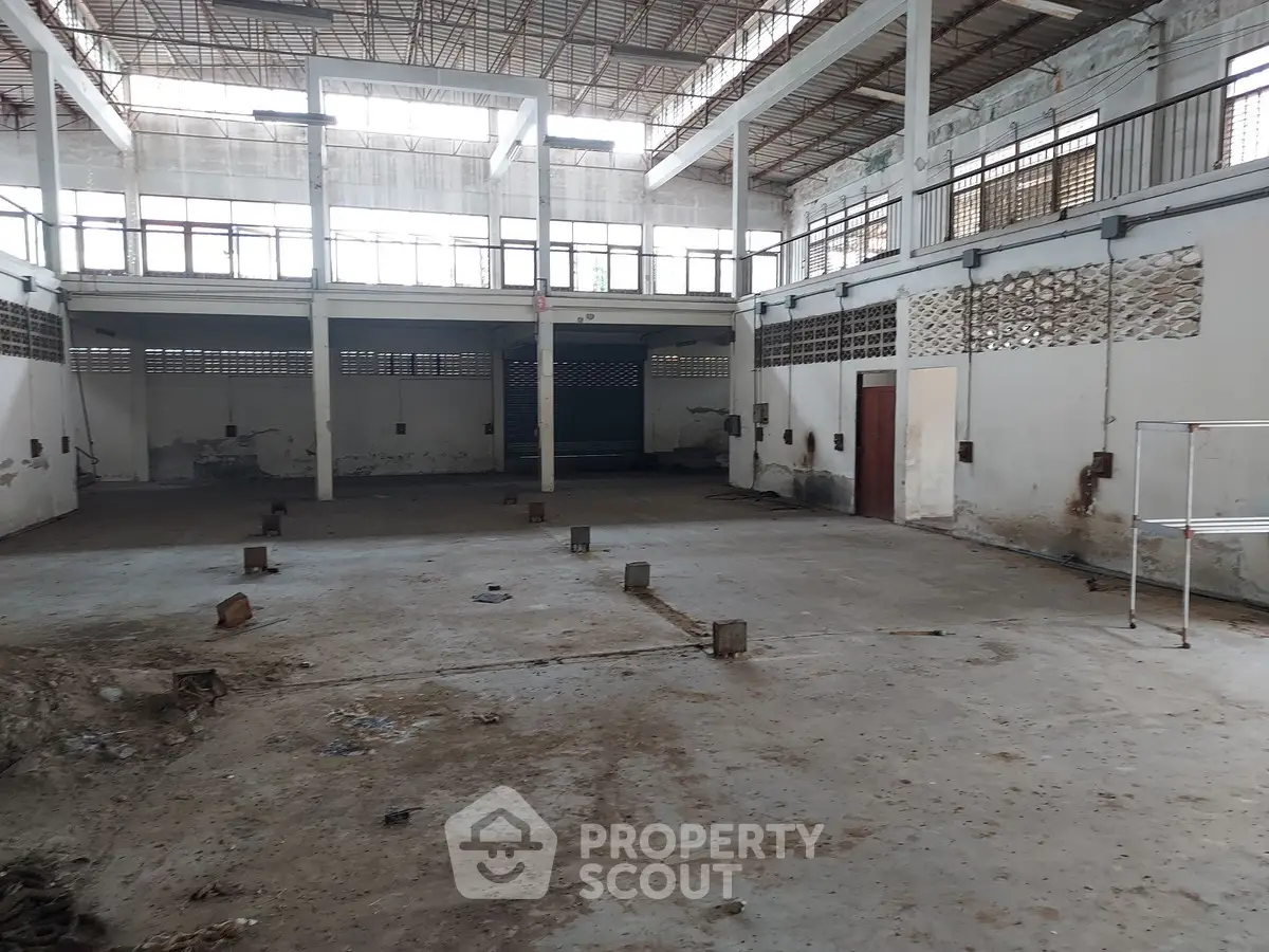 Spacious industrial warehouse with high ceilings and ample natural light.