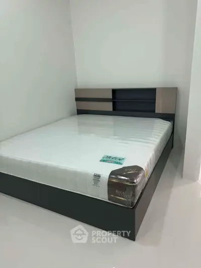 Modern bedroom with sleek bed frame and minimalist design, perfect for contemporary living.