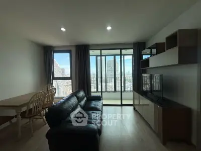 Modern living room with city view, featuring sleek furniture and large windows for natural light.