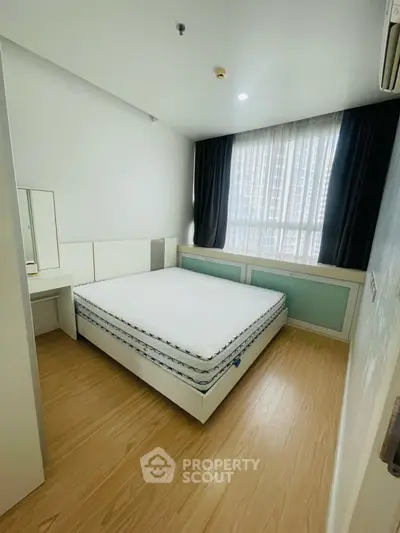 Modern bedroom with natural light and minimalist design in a high-rise apartment.