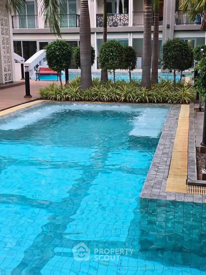 Luxurious residential pool area with lush greenery and modern design.