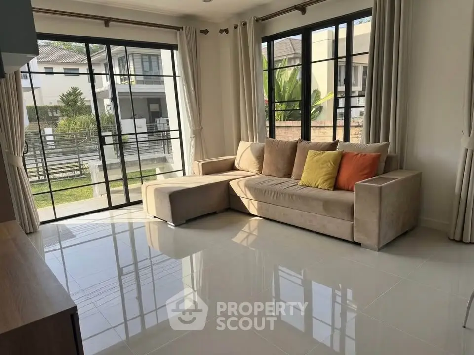 Spacious living room with large windows and modern sofa in a bright, airy home.