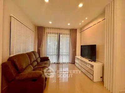 Cozy living room with plush sofa and modern TV setup, perfect for relaxation.