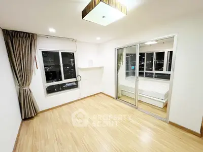 Spacious bedroom with wooden flooring and city view in modern apartment