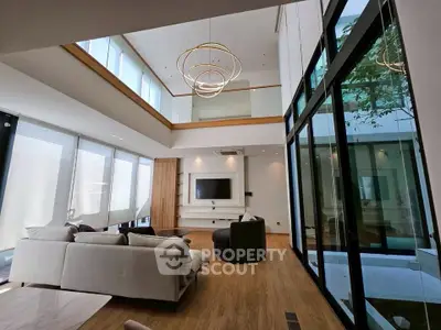 Luxurious modern living room with high ceilings and elegant lighting in a spacious open layout.