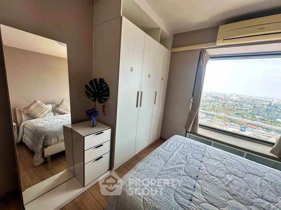Cozy bedroom with large window offering stunning city view, featuring modern wardrobe and stylish decor.