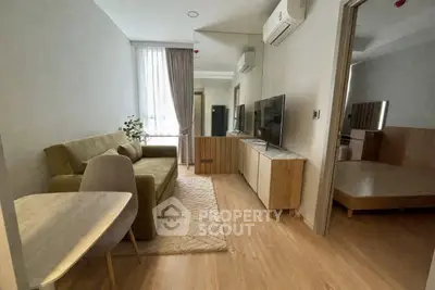Modern living room with cozy sofa, TV, and wooden flooring in a stylish apartment.