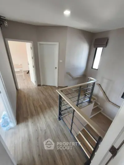 Modern interior hallway with wooden flooring and staircase