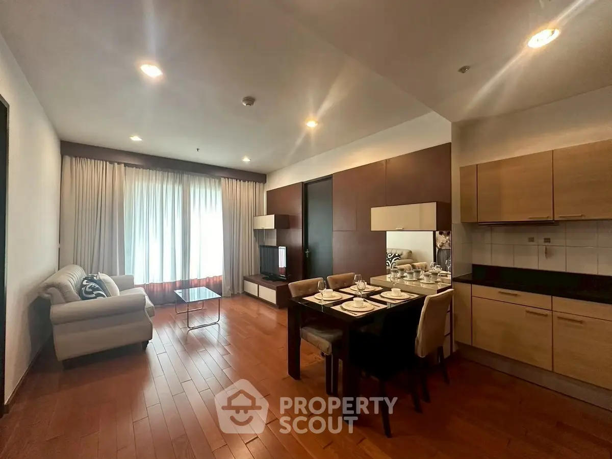 Spacious open-plan living and dining area with modern kitchen in elegant apartment.