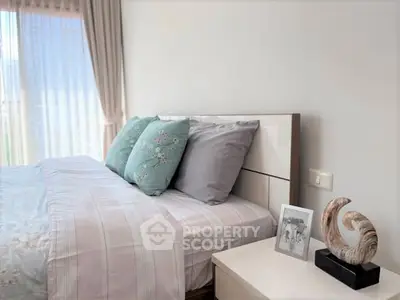 Cozy bedroom with stylish decor and natural light, perfect for relaxation.