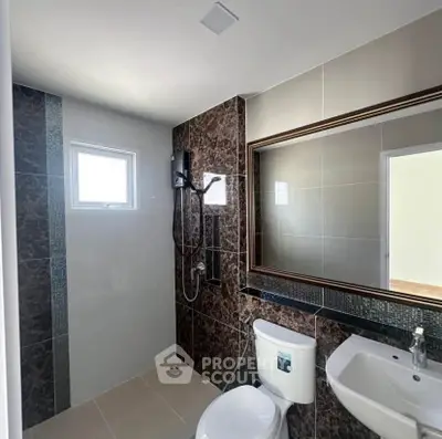 Modern bathroom with sleek design, featuring a large mirror and stylish shower area.
