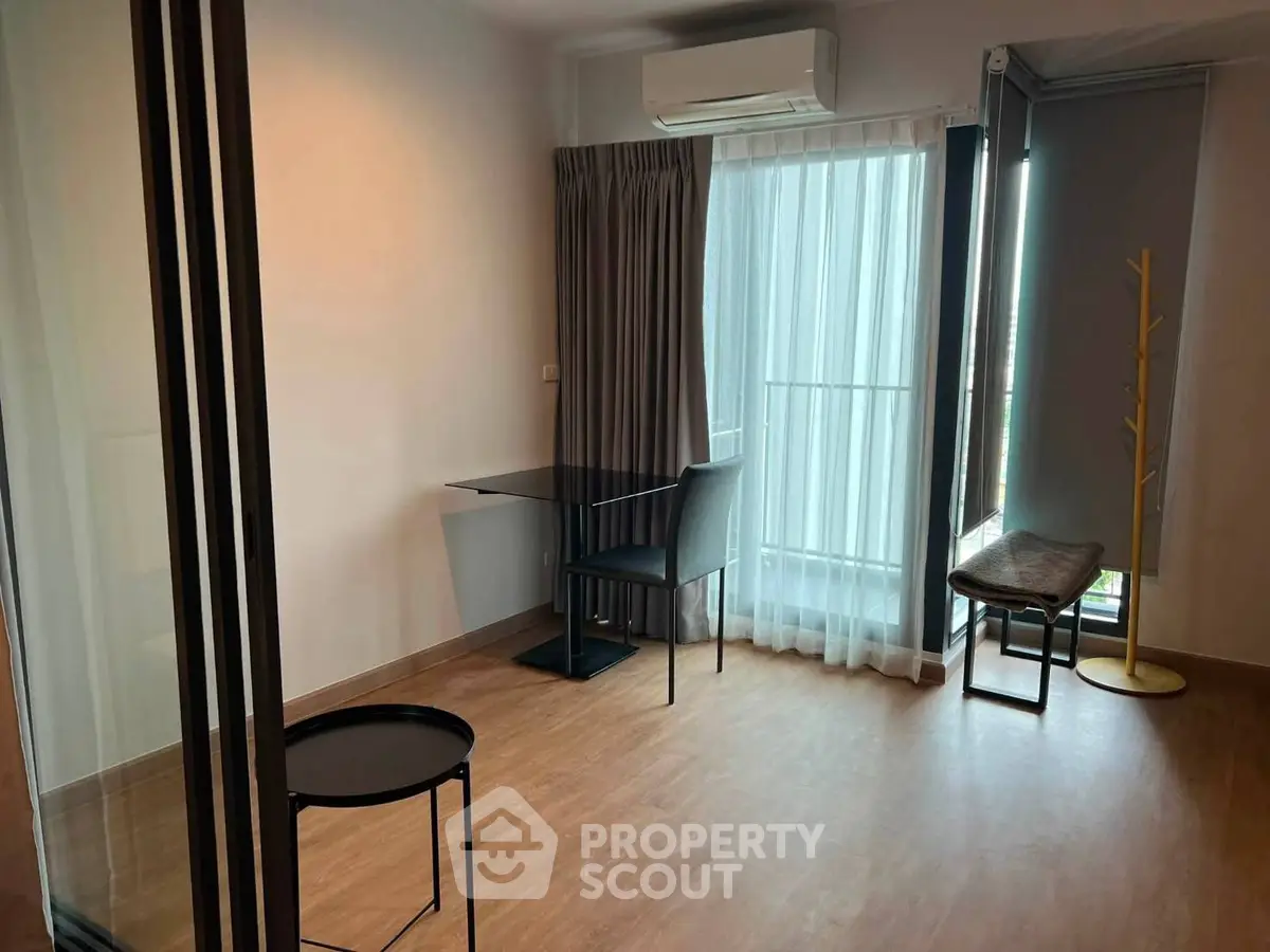Modern living room with large windows and stylish furniture in a bright apartment.
