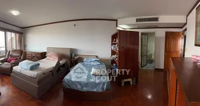 Spacious bedroom with twin beds and wooden flooring, ideal for comfort and relaxation.