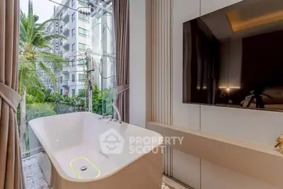 Luxurious bathroom with modern bathtub and large window view in high-rise apartment.