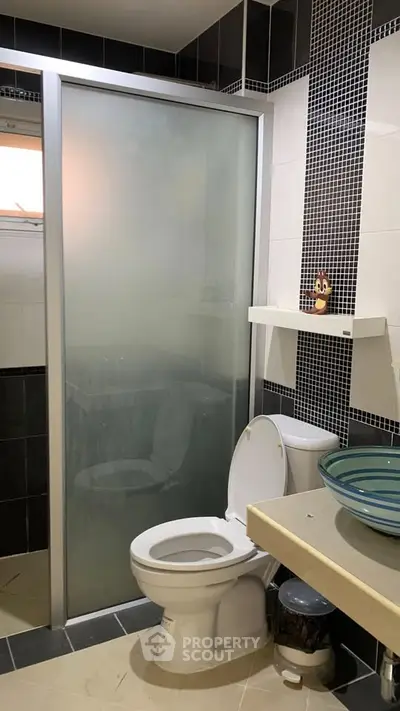 Modern bathroom with glass shower and stylish sink in contemporary design.