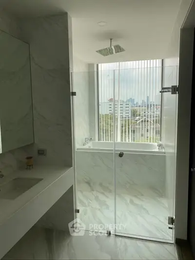 Modern bathroom with glass shower and city view