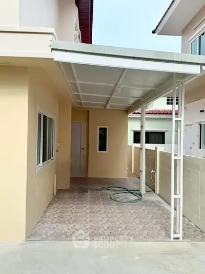 Spacious covered patio area with tiled flooring and modern design.