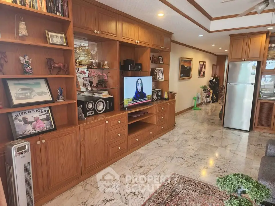 Spacious living room with wooden cabinetry and marble flooring