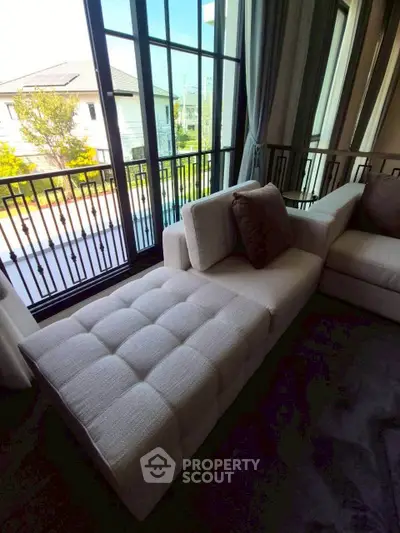 Luxurious living room with plush chaise lounge and large windows offering a serene view.