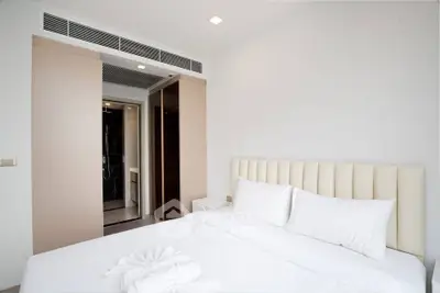 Modern bedroom with elegant design and ensuite bathroom in luxury apartment.