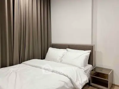 Cozy bedroom with elegant curtains and modern bedside table, perfect for restful nights.