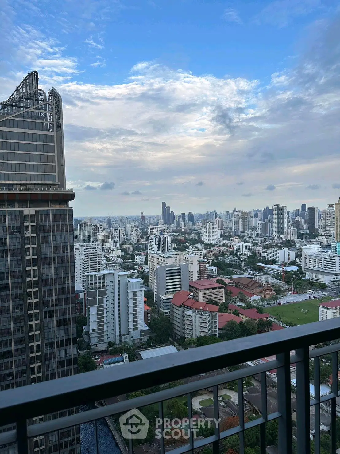 Stunning cityscape view from high-rise balcony with expansive skyline and modern architecture.